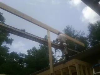 Carpenter setting a ridge beam over a new addition frame — Ice Dam Removal by Roofing Brothers in Allamuchy