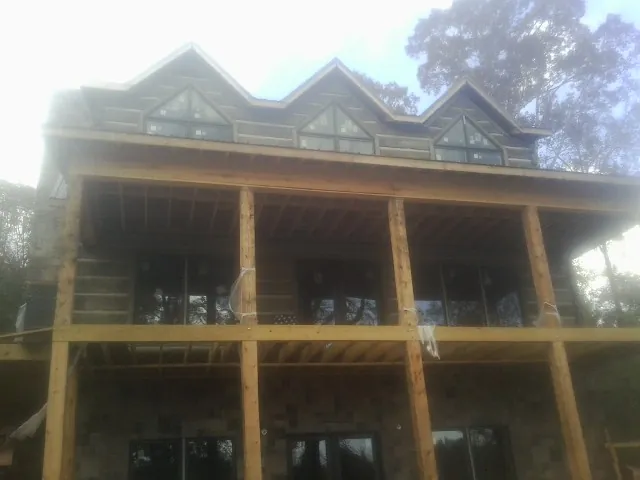 Dormers and porch framing on a large log home under construction — Roof Coating work by our crew in Allamuchy