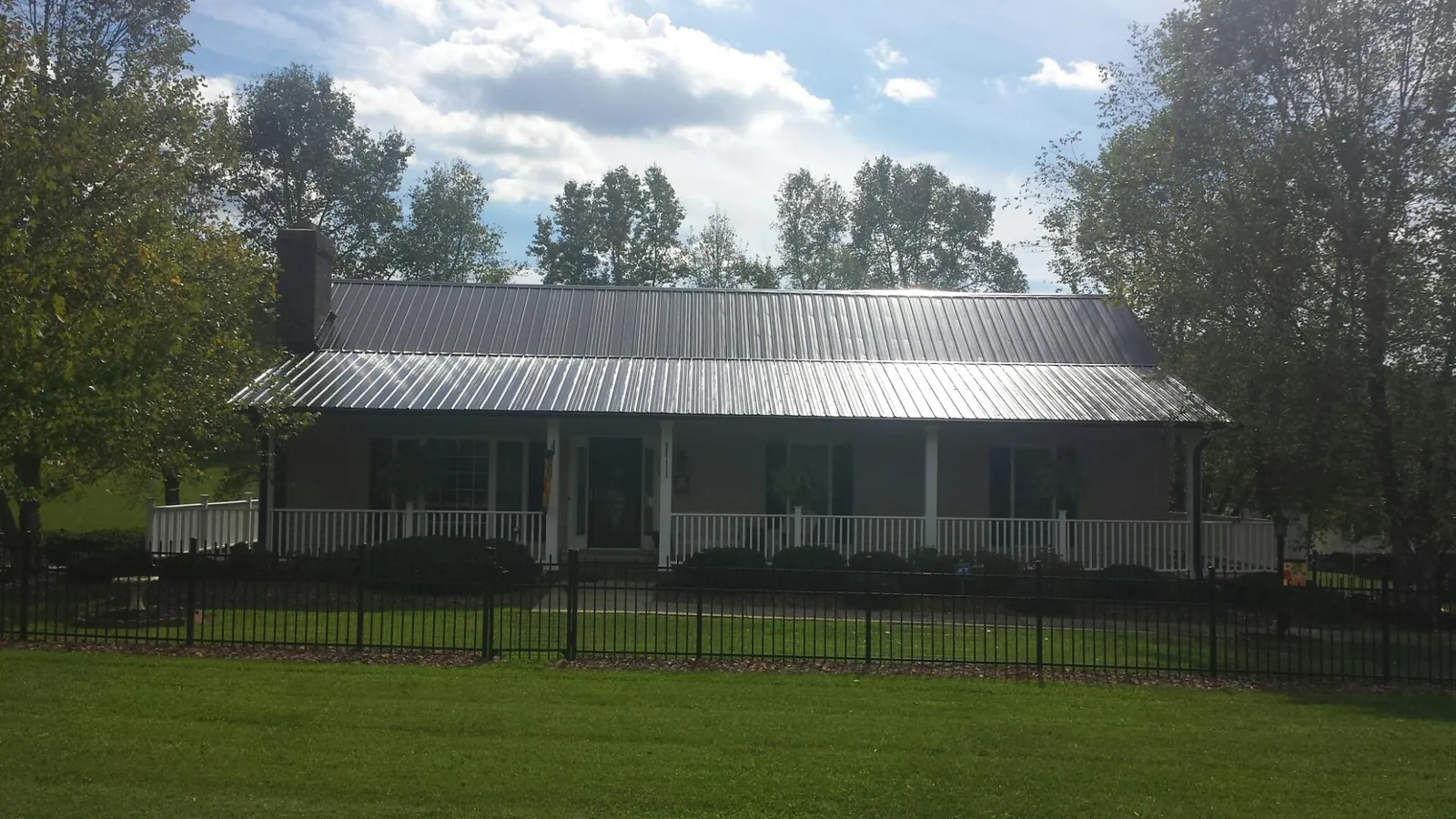 Gray metal roof on a brick ranch with a full width front porch — Gutter Guard Installation work by our crew in Allamuchy