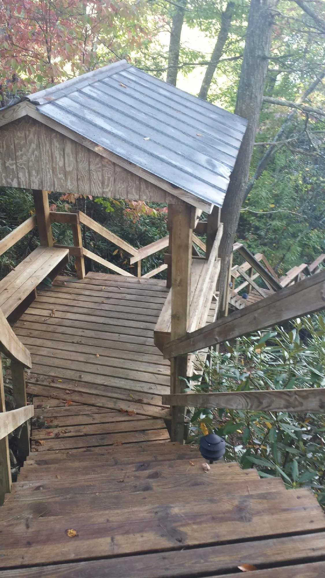 Metal roofed shelter over wooden steps on a wooded walkway — Skylight Repair & Installation work by our crew in Allamuchy