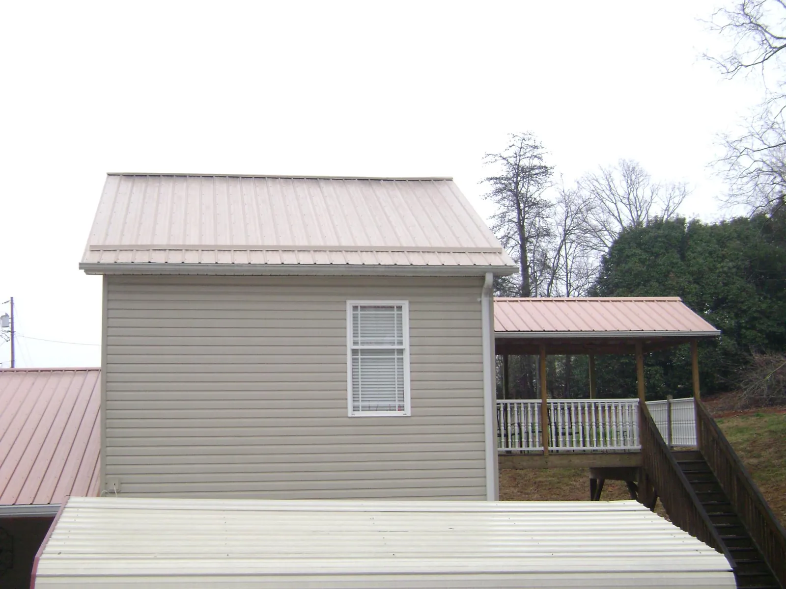 Tan metal roofs on a two story addition and attached porch, from a Roof Replacement job in Allamuchy